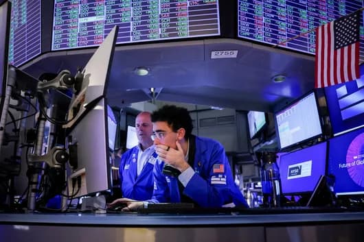 Traders working at a desk on the New York Stock Exchange floor