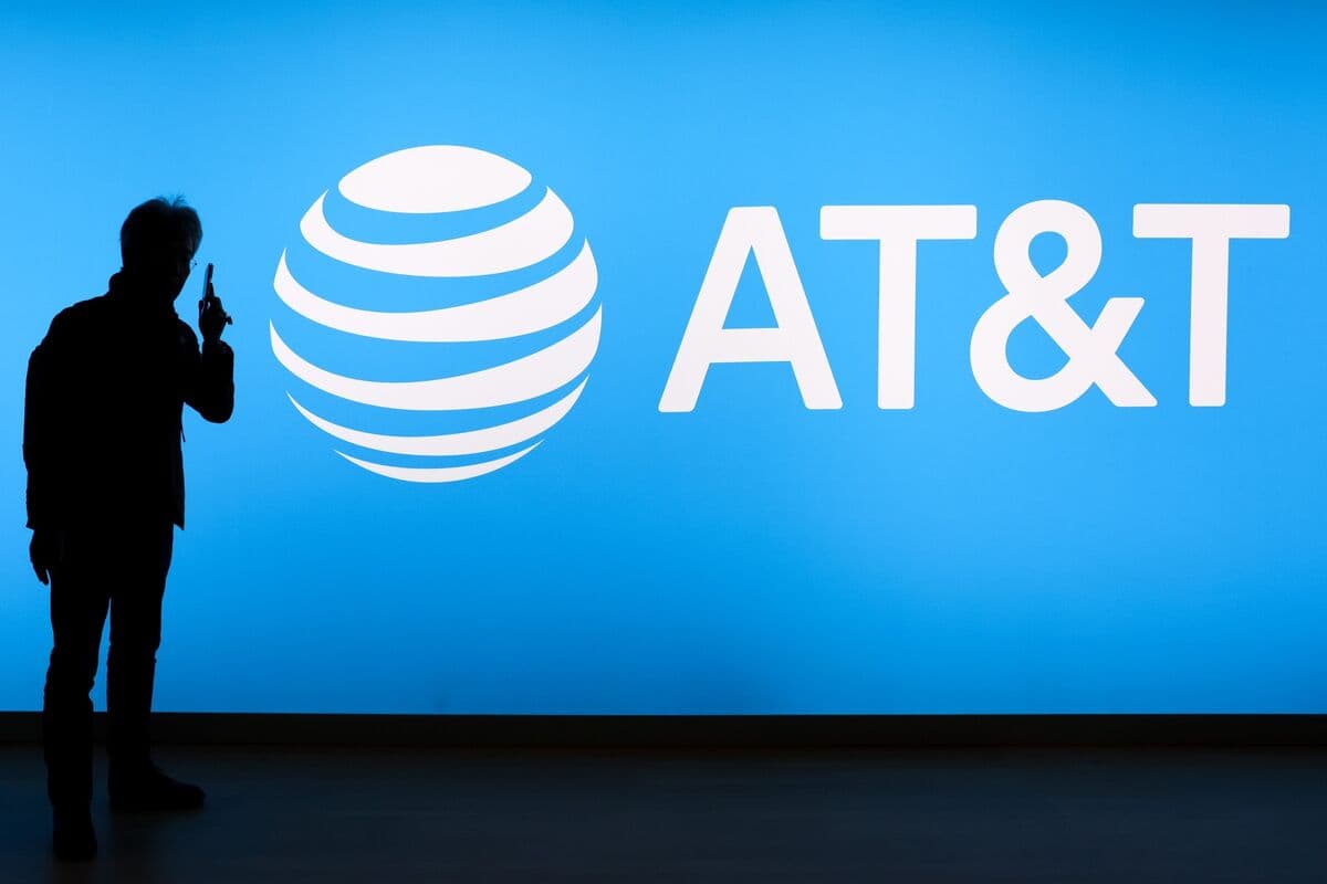 A silhouetted figure standing in front of an illuminated AT&T logo