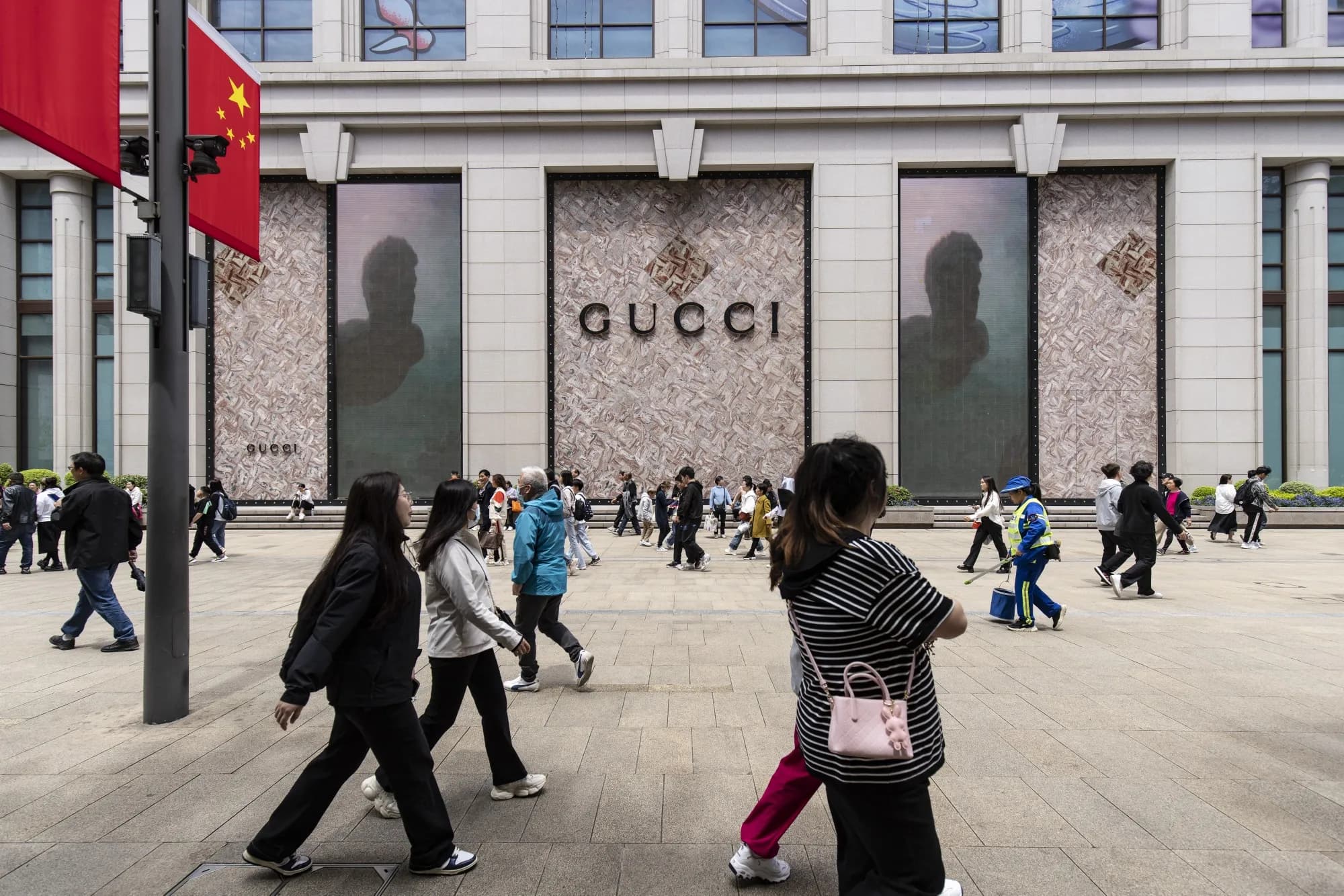 Shoppers walking past a Gucci storefront in China