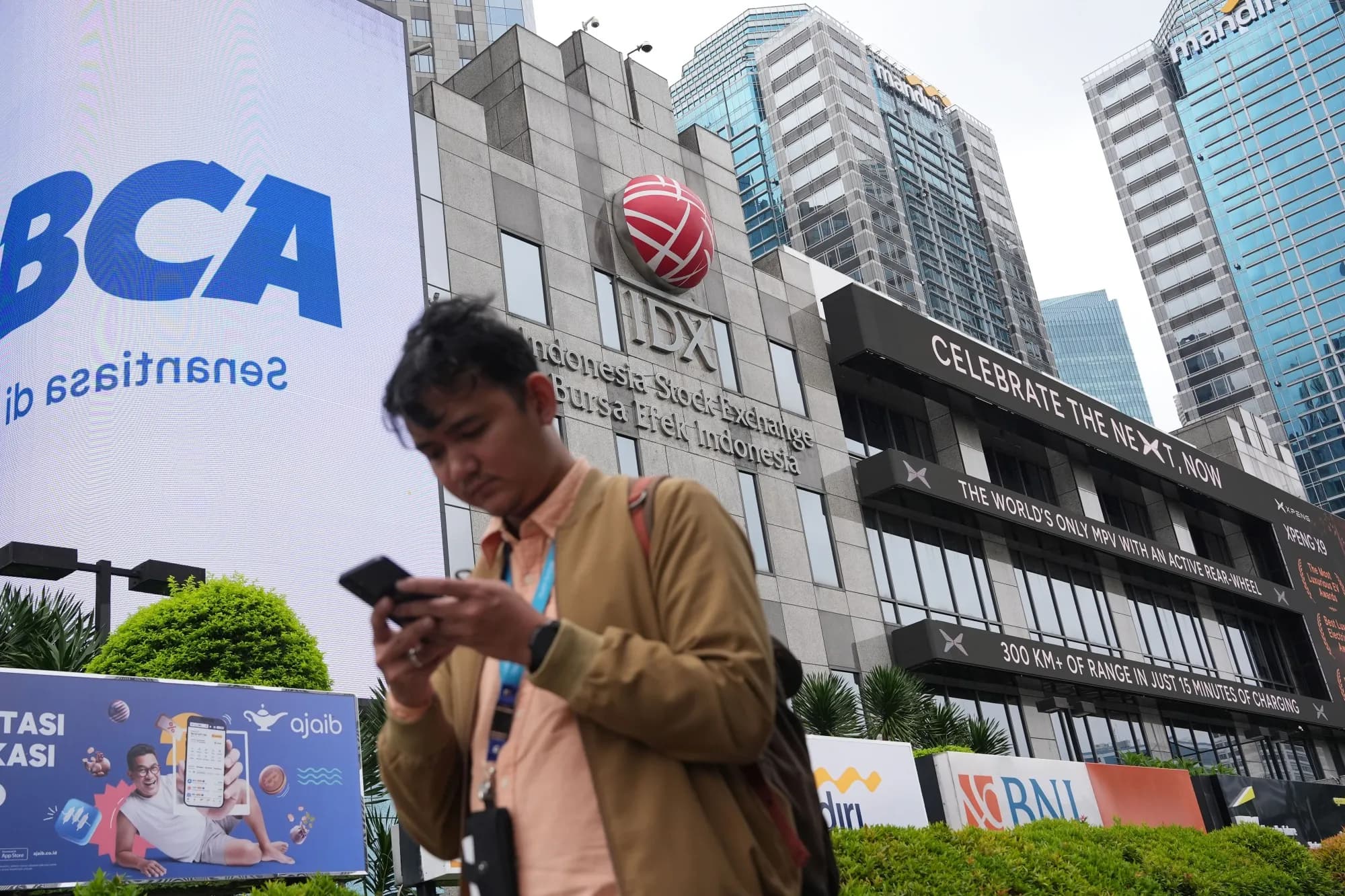 A pedestrian using a phone outside the Indonesia Stock Exchange building in Jakarta