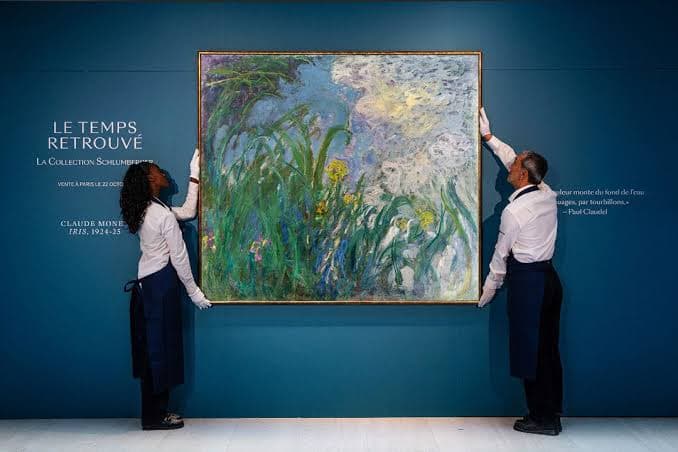 Sotheby's staff hanging Claude Monet's painting Iris before auction in Paris