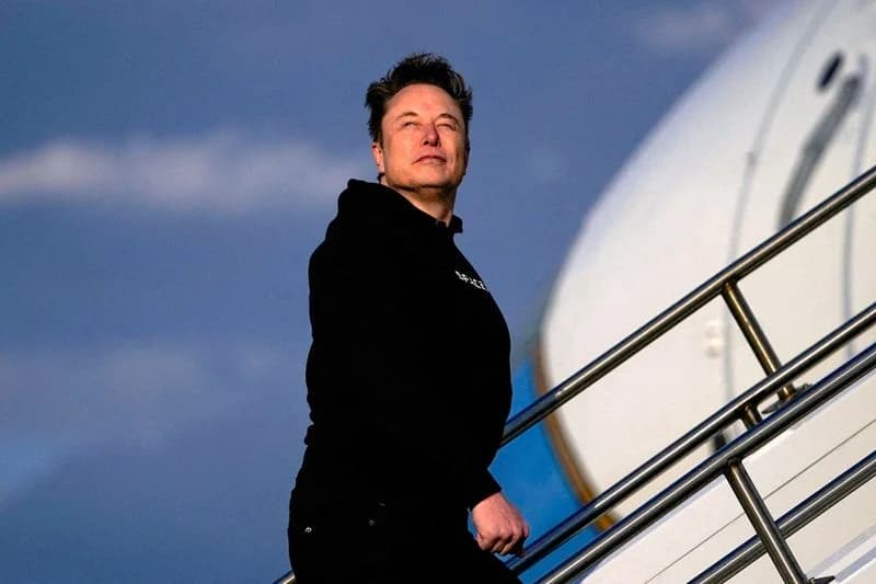 Elon Musk walking down airplane stairs