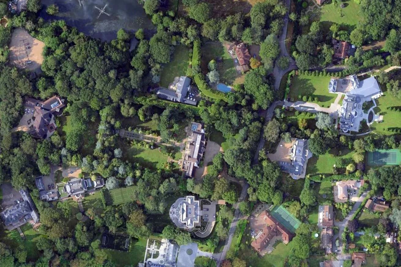 Aerial view of large estates and mansions in a wooded Surrey neighborhood