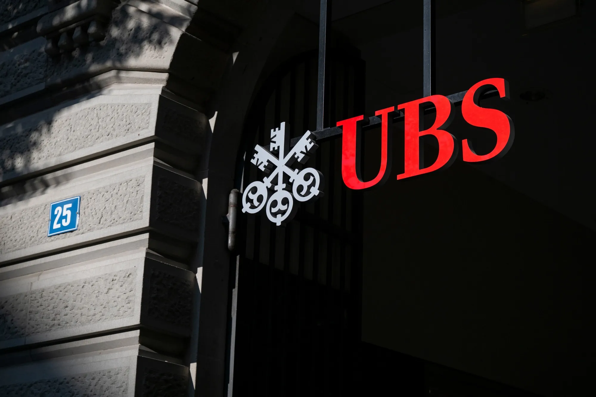 The UBS logo mounted outside a bank branch entrance