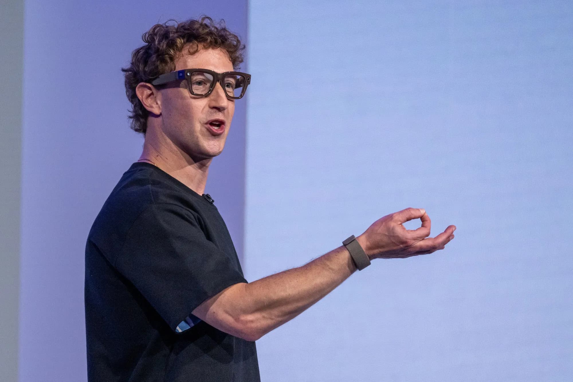 Mark Zuckerberg speaking on stage while wearing smart glasses