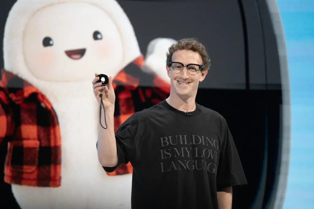 Mark Zuckerberg holding a device on stage in front of a Muse character display